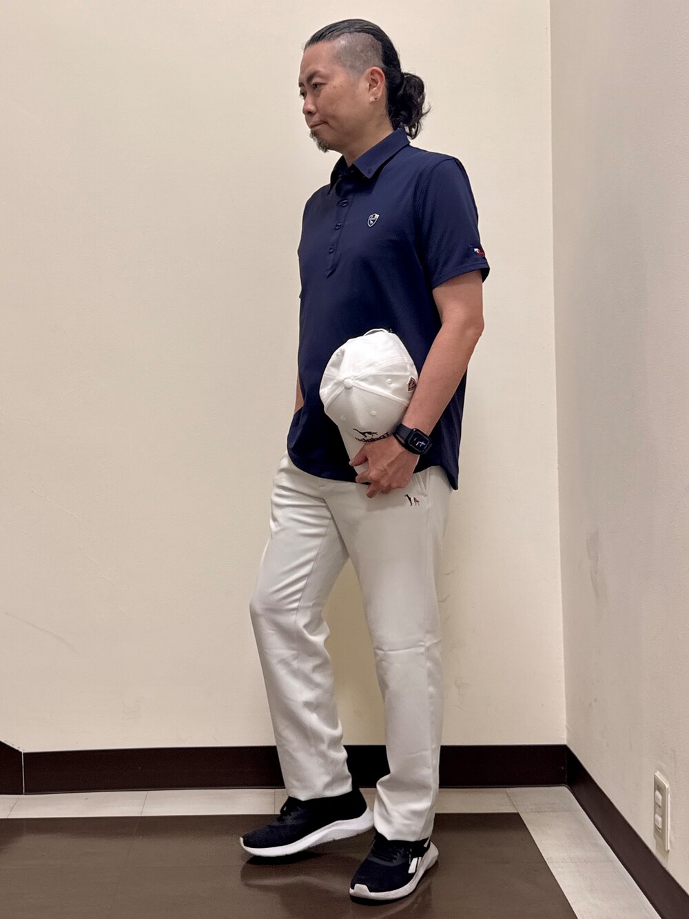 ブルー系のポロシャツ、グレー系のその他パンツ、ホワイト系のキャップを着用したメンズの夏コーディネートの6枚目の写真