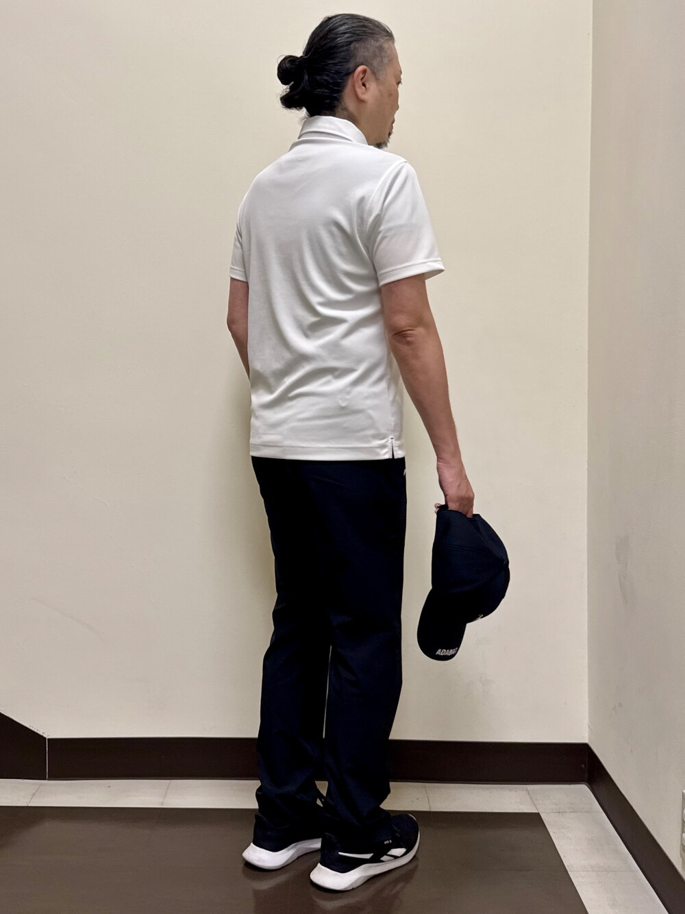 ホワイト系のポロシャツ、ブラック系のその他パンツ、ブラック系のキャップを着用したメンズの夏コーディネートの5枚目の写真