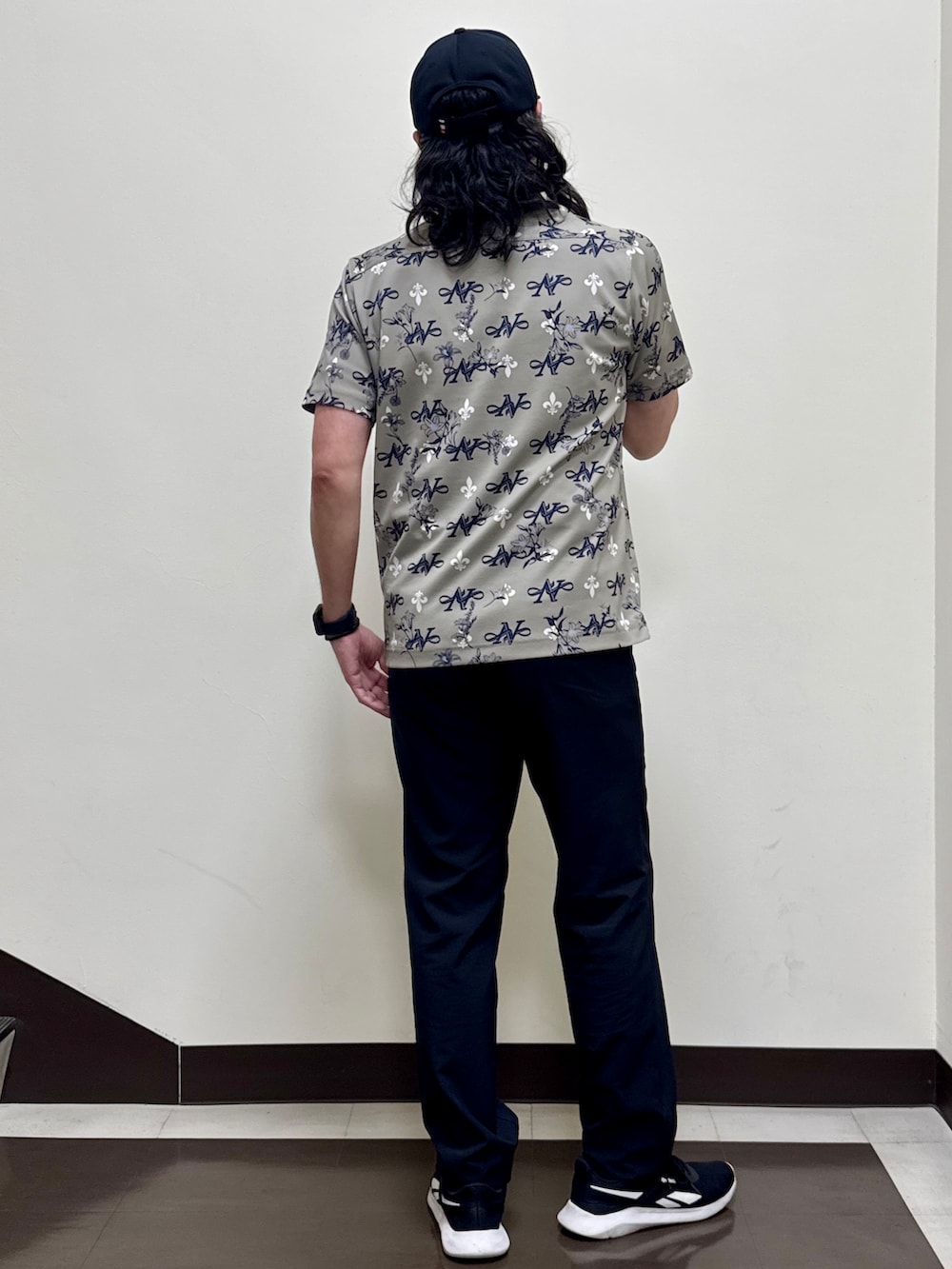 ベージュ系のポロシャツ、ブラック系のその他パンツ、ブラック系のキャップを着用したメンズの夏コーディネートの2枚目の写真