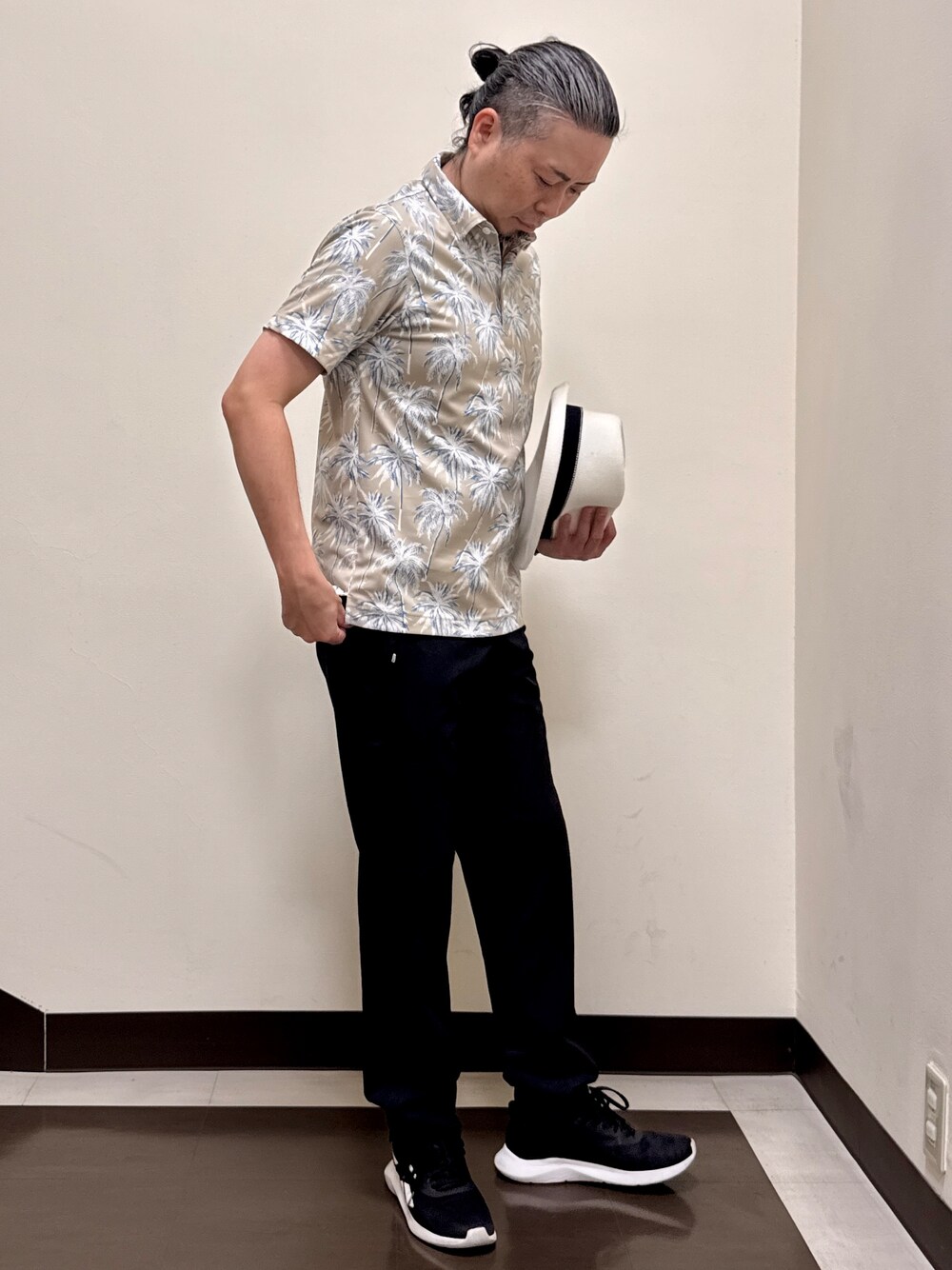 ベージュ系のポロシャツ、ブラック系のその他パンツ、ブラック系のキャップを着用したメンズの夏コーディネートの6枚目の写真