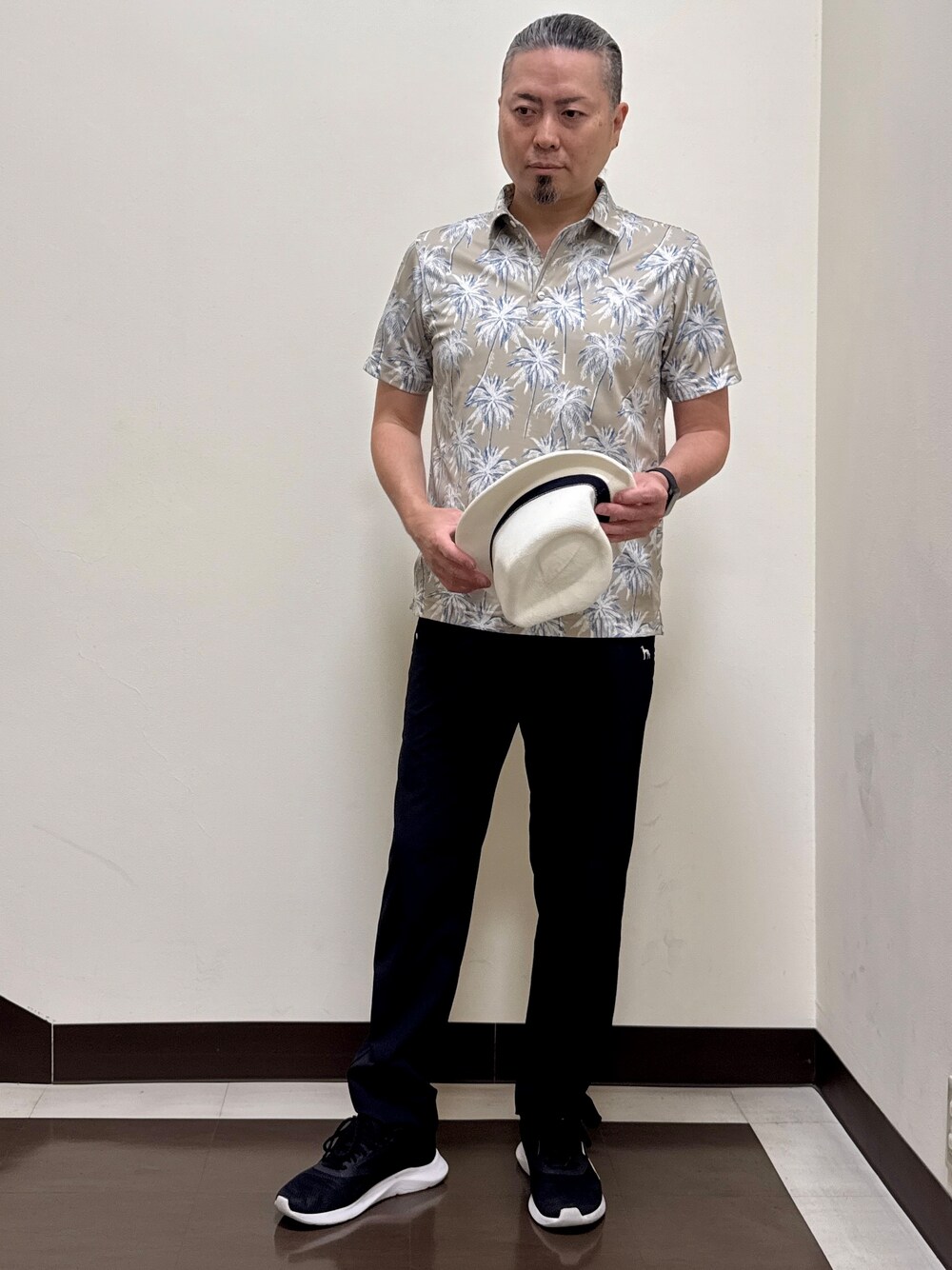 ベージュ系のポロシャツ、ブラック系のその他パンツ、ブラック系のキャップを着用したメンズの夏コーディネートの8枚目の写真
