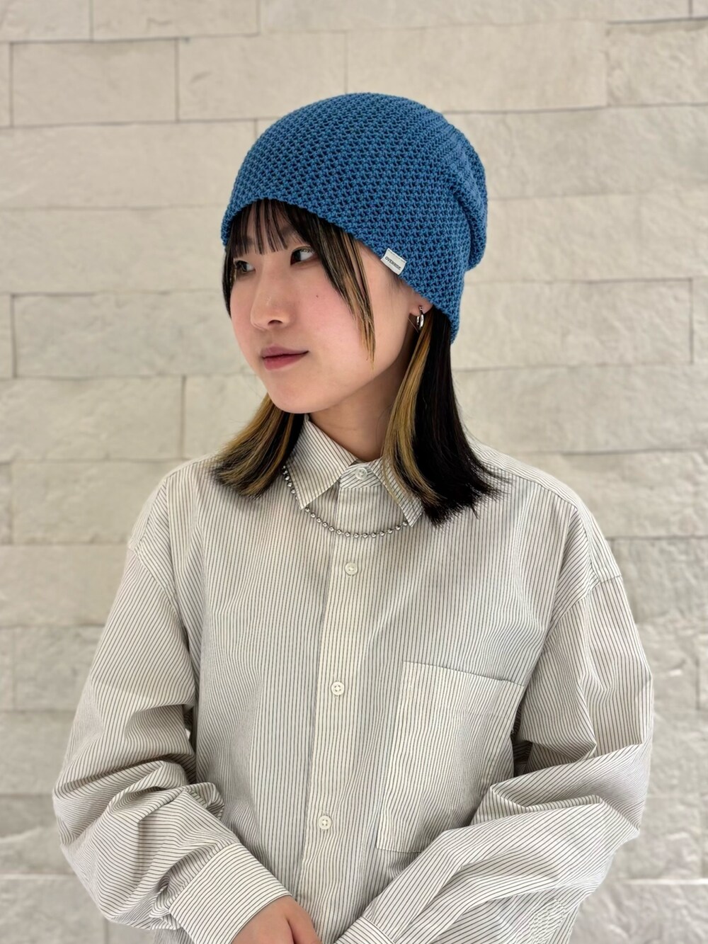 ホワイト系のシャツ/ブラウス、ブラック系のデニムスカート、グレー系のスニーカーを着用したレディースの春コーディネートの3枚目の写真