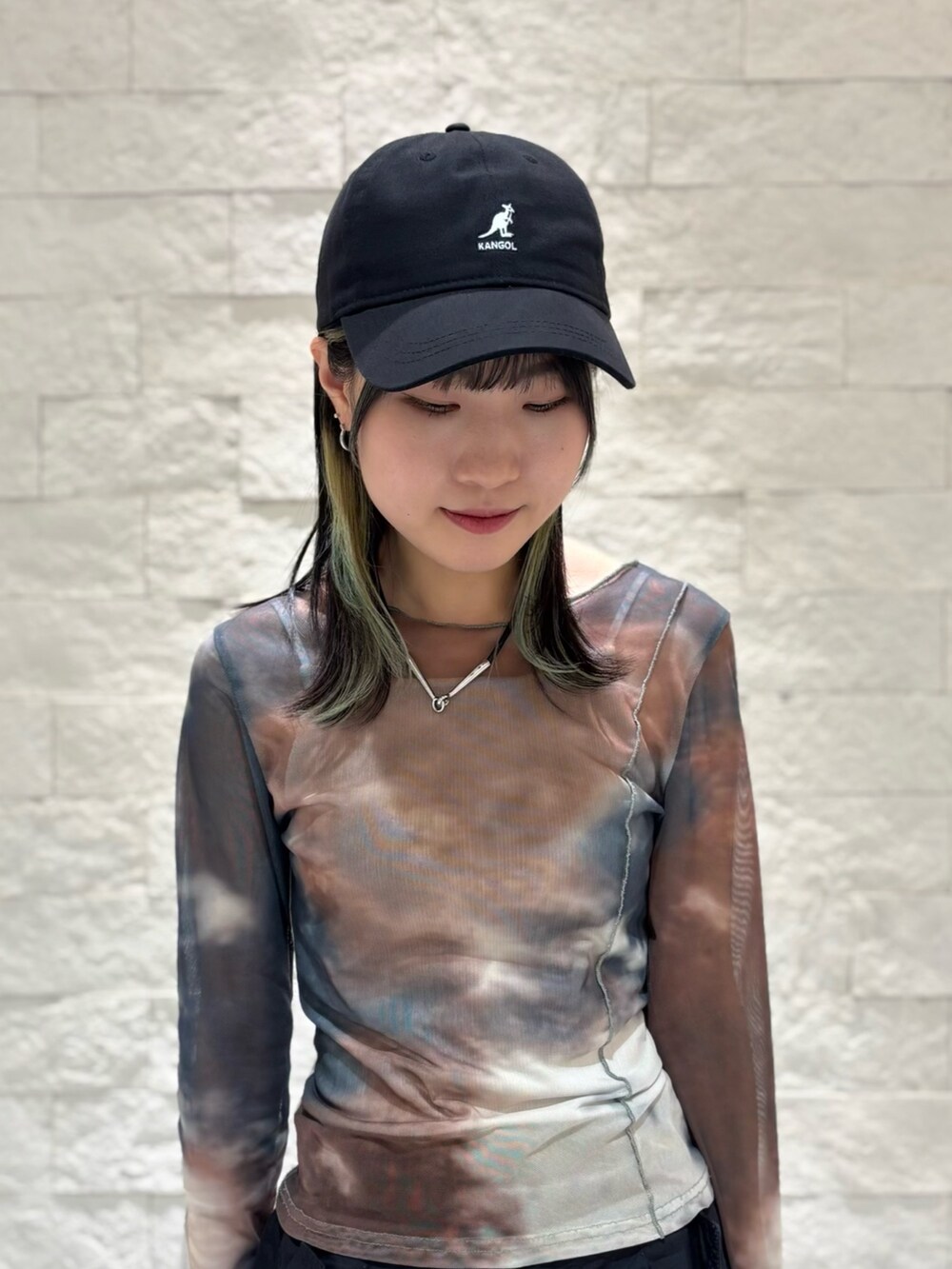 ブラック系のスニーカー、ブラック系のキャップを着用したレディースの夏コーディネートの3枚目の写真