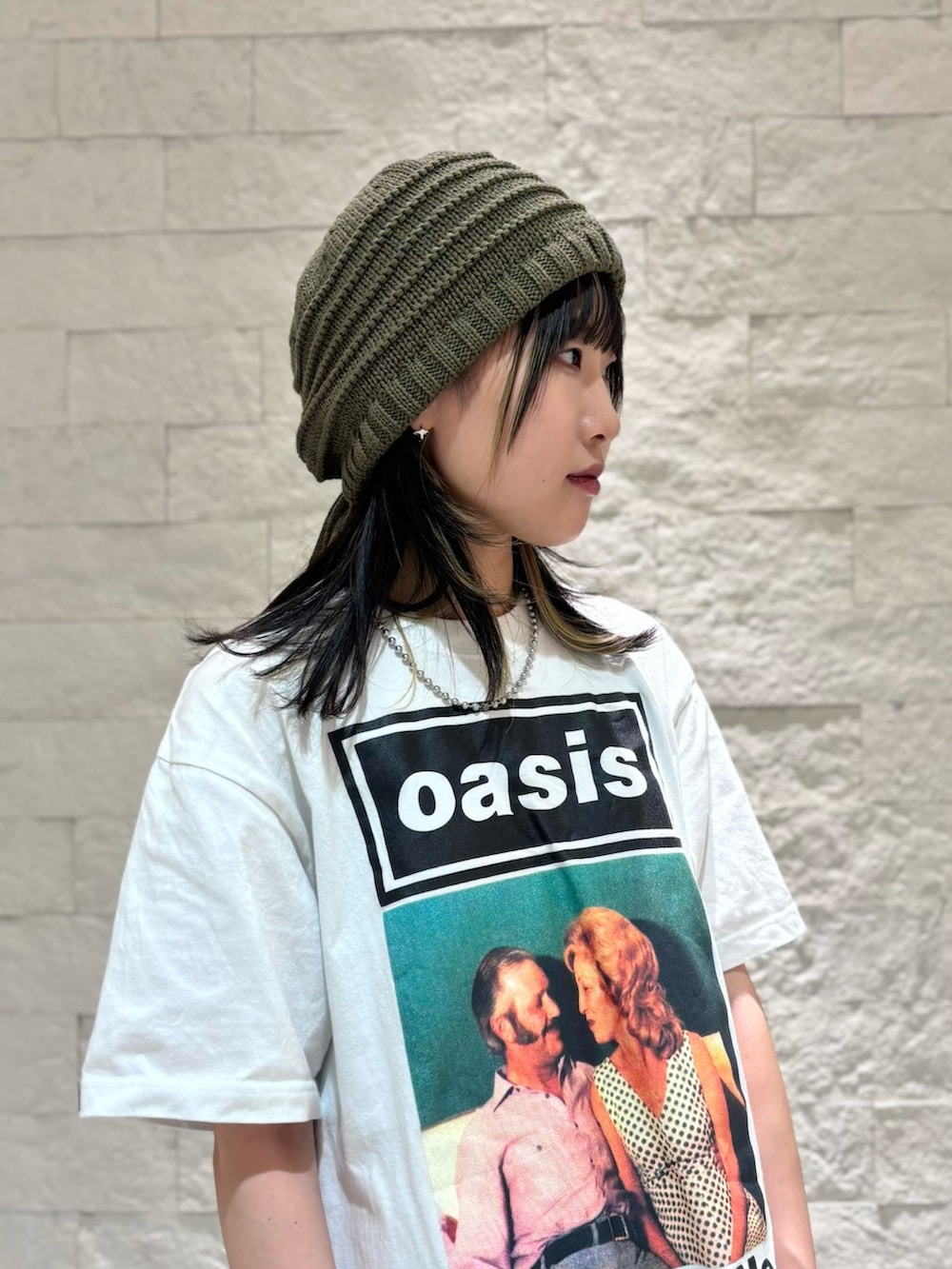 グレー系のスカート、シルバー系のスニーカー、グリーン系のニットキャップ/ビーニーを着用したレディースの夏コーディネートの4枚目の写真