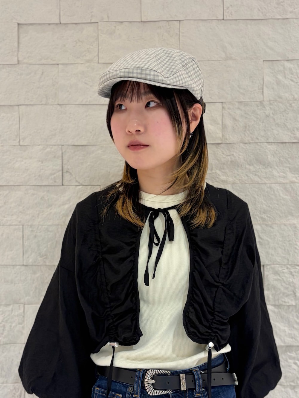 ブラック系のカーディガン/ボレロ、ブルー系のデニムパンツ、ブラック系のスニーカーを着用したレディースの春コーディネートの3枚目の写真