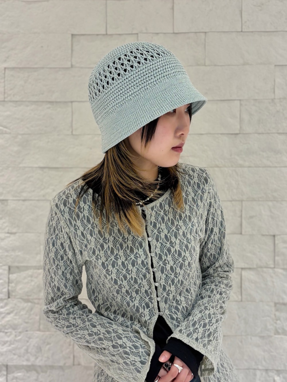 ベージュ系のカーディガン/ボレロ、ブルー系のデニムパンツ、ブラック系のスニーカーを着用したレディースの春コーディネートの2枚目の写真