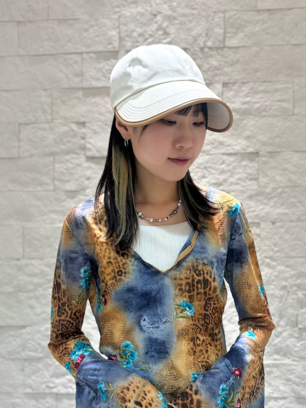 ブルー系のデニムパンツ、ベージュ系のスニーカー、ベージュ系のキャップを着用したレディースの夏コーディネートの3枚目の写真