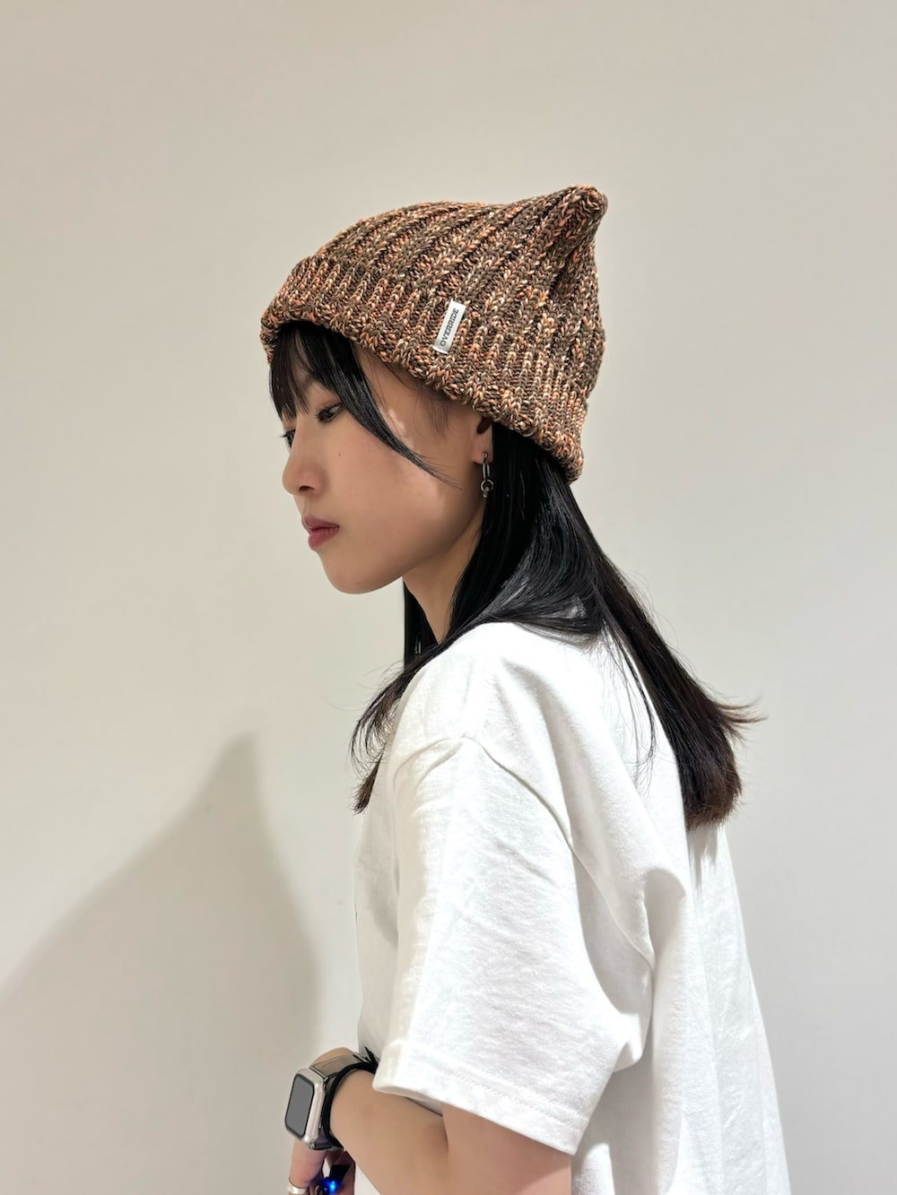 シルバー系のワンピース/ドレス、ブラック系のデニムパンツ、ベージュ系のスニーカーを着用したレディースの夏コーディネートの4枚目の写真