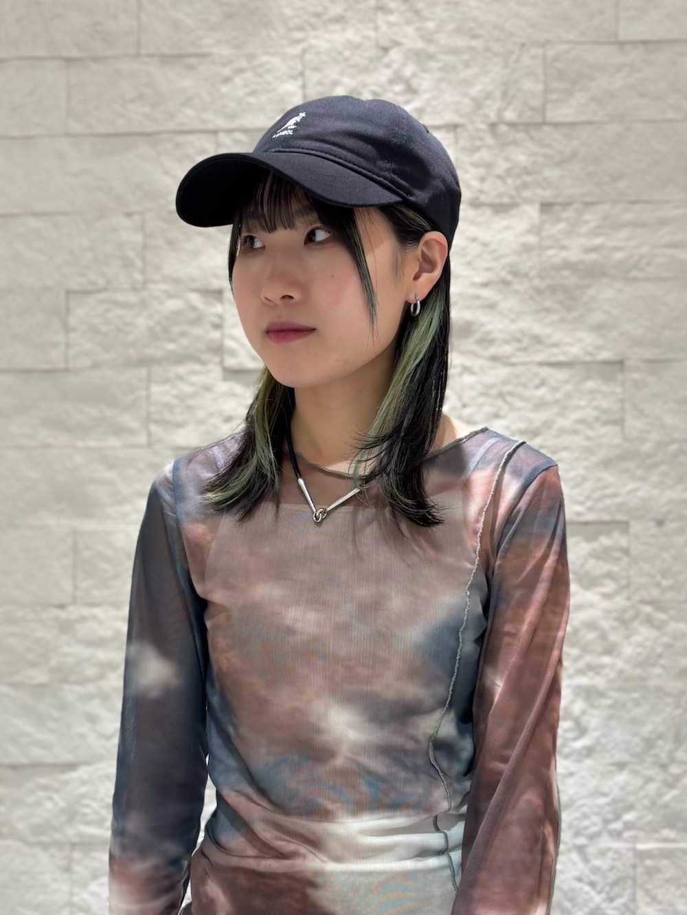 ブラック系のスニーカー、ブラック系のキャップを着用したレディースの夏コーディネートの2枚目の写真