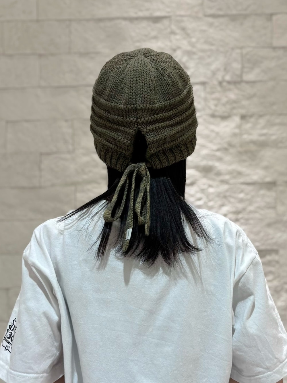 グレー系のスカート、シルバー系のスニーカー、グリーン系のニットキャップ/ビーニーを着用したレディースの夏コーディネートの5枚目の写真