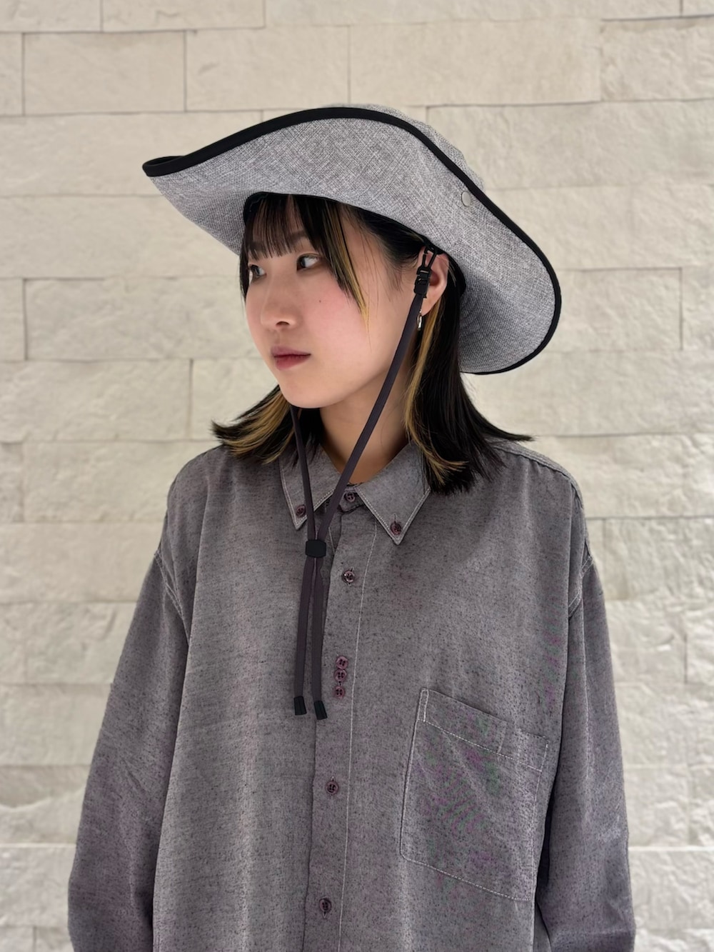 グレー系のシャツ/ブラウス、シルバー系のワンピース/ドレス、ブラック系のデニムパンツを着用したレディースの春コーディネートの3枚目の写真