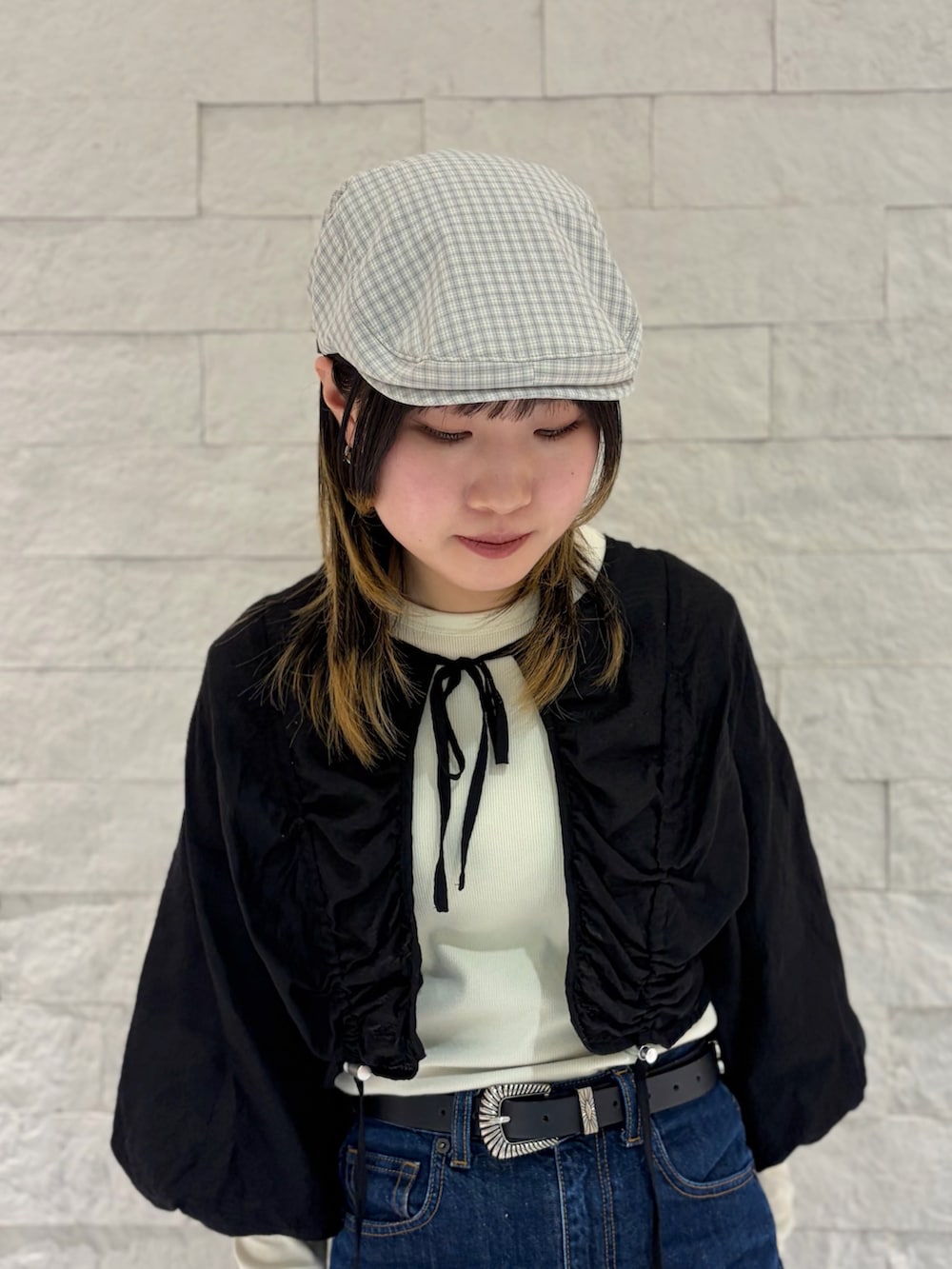 ブラック系のカーディガン/ボレロ、ブルー系のデニムパンツ、ブラック系のスニーカーを着用したレディースの春コーディネートの4枚目の写真