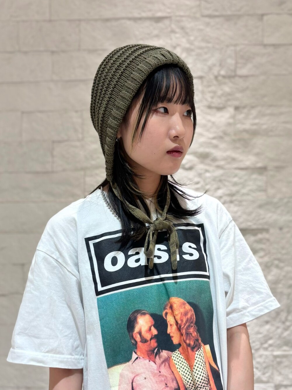 グレー系のスカート、シルバー系のスニーカー、グリーン系のニットキャップ/ビーニーを着用したレディースの夏コーディネートの3枚目の写真