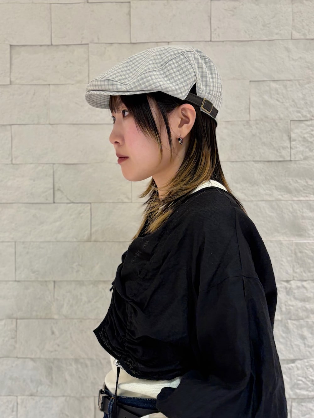 ブラック系のカーディガン/ボレロ、ブルー系のデニムパンツ、ブラック系のスニーカーを着用したレディースの春コーディネートの2枚目の写真