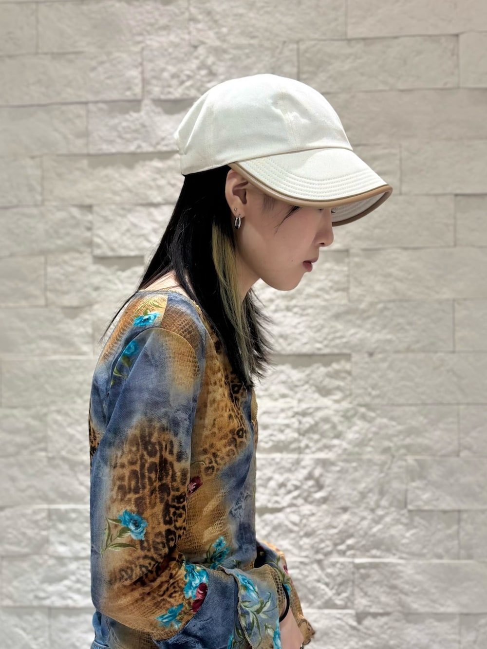 ブルー系のデニムパンツ、ベージュ系のスニーカー、ベージュ系のキャップを着用したレディースの夏コーディネートの5枚目の写真