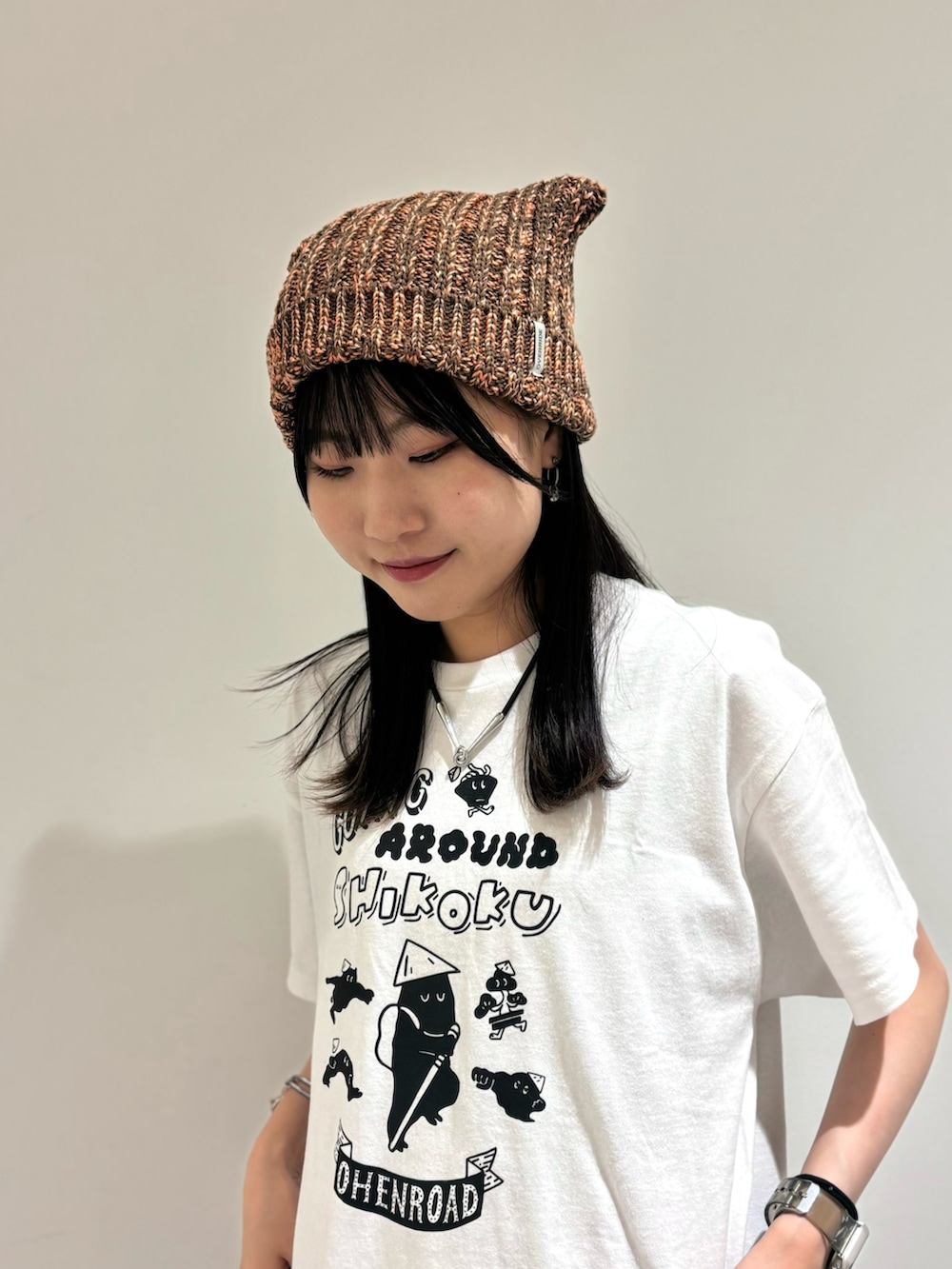 シルバー系のワンピース/ドレス、ブラック系のデニムパンツ、ベージュ系のスニーカーを着用したレディースの夏コーディネートの3枚目の写真