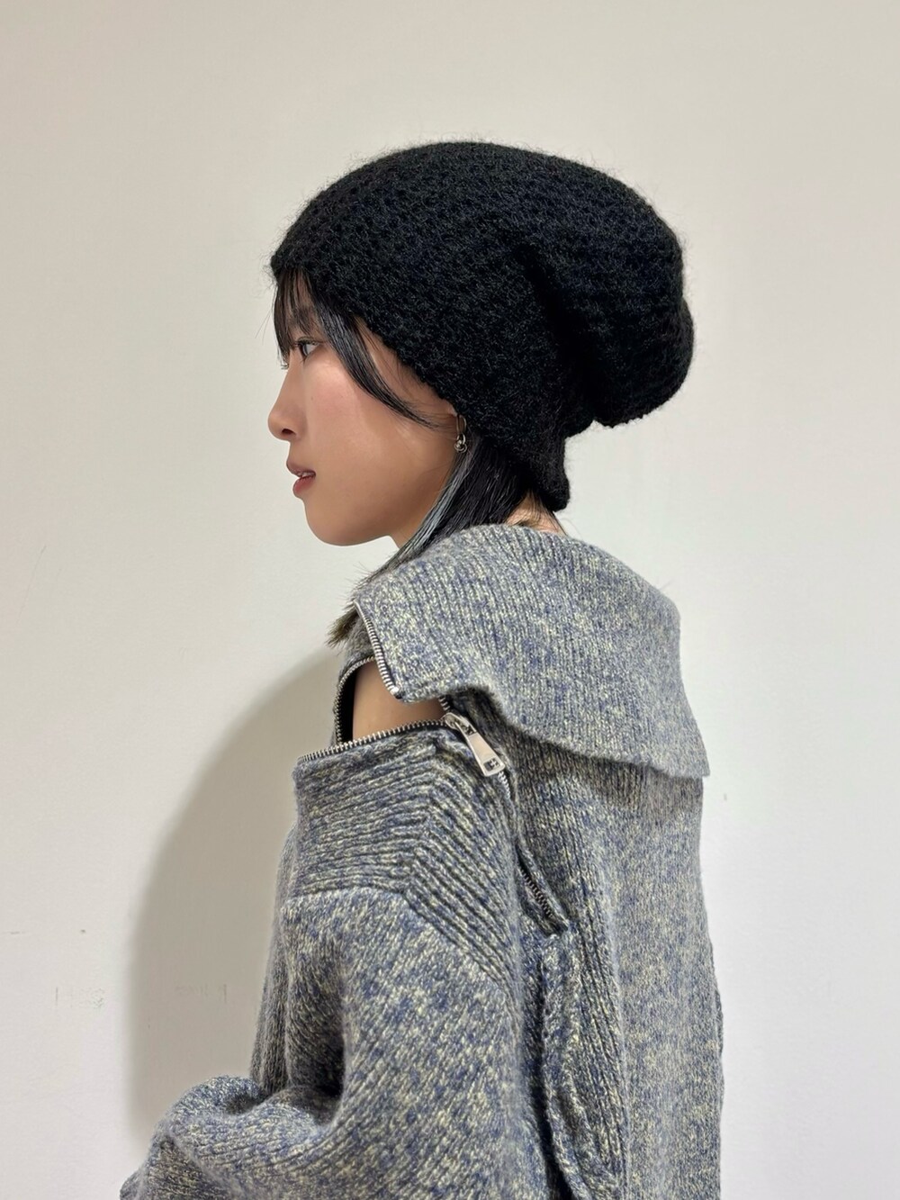 ブラック系のデニムパンツ、ブラック系のローファー、ブルー系のニット/セーターを着用したレディースの秋コーディネートの4枚目の写真