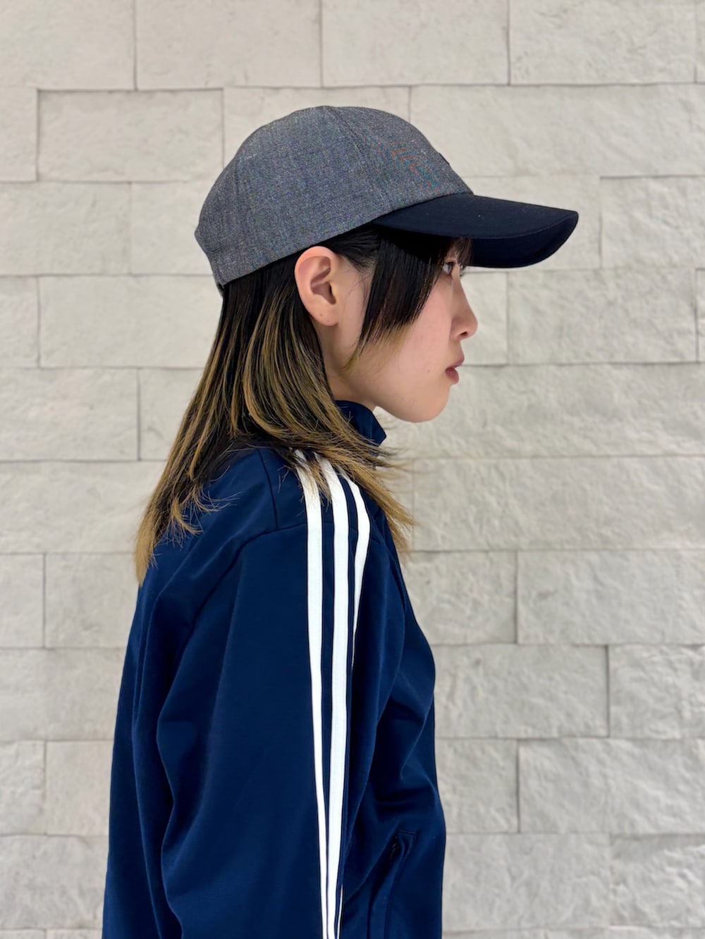 ブルー系のジャージ、グレー系のスカート、ブラック系のスニーカーを着用したレディースの春コーディネートの4枚目の写真