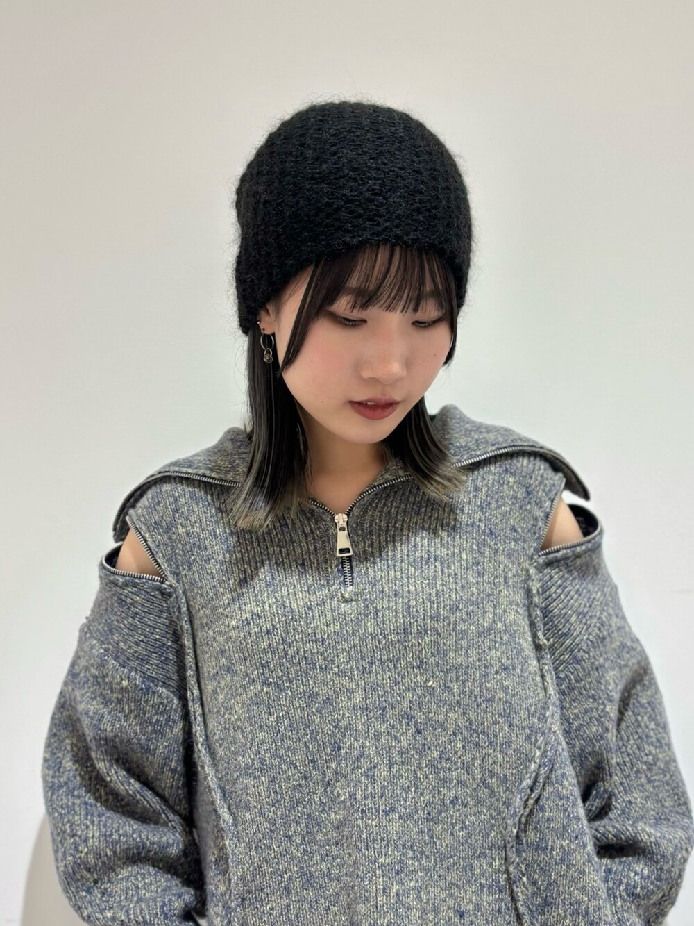 ブラック系のデニムパンツ、ブラック系のローファー、ブルー系のニット/セーターを着用したレディースの秋コーディネートの3枚目の写真