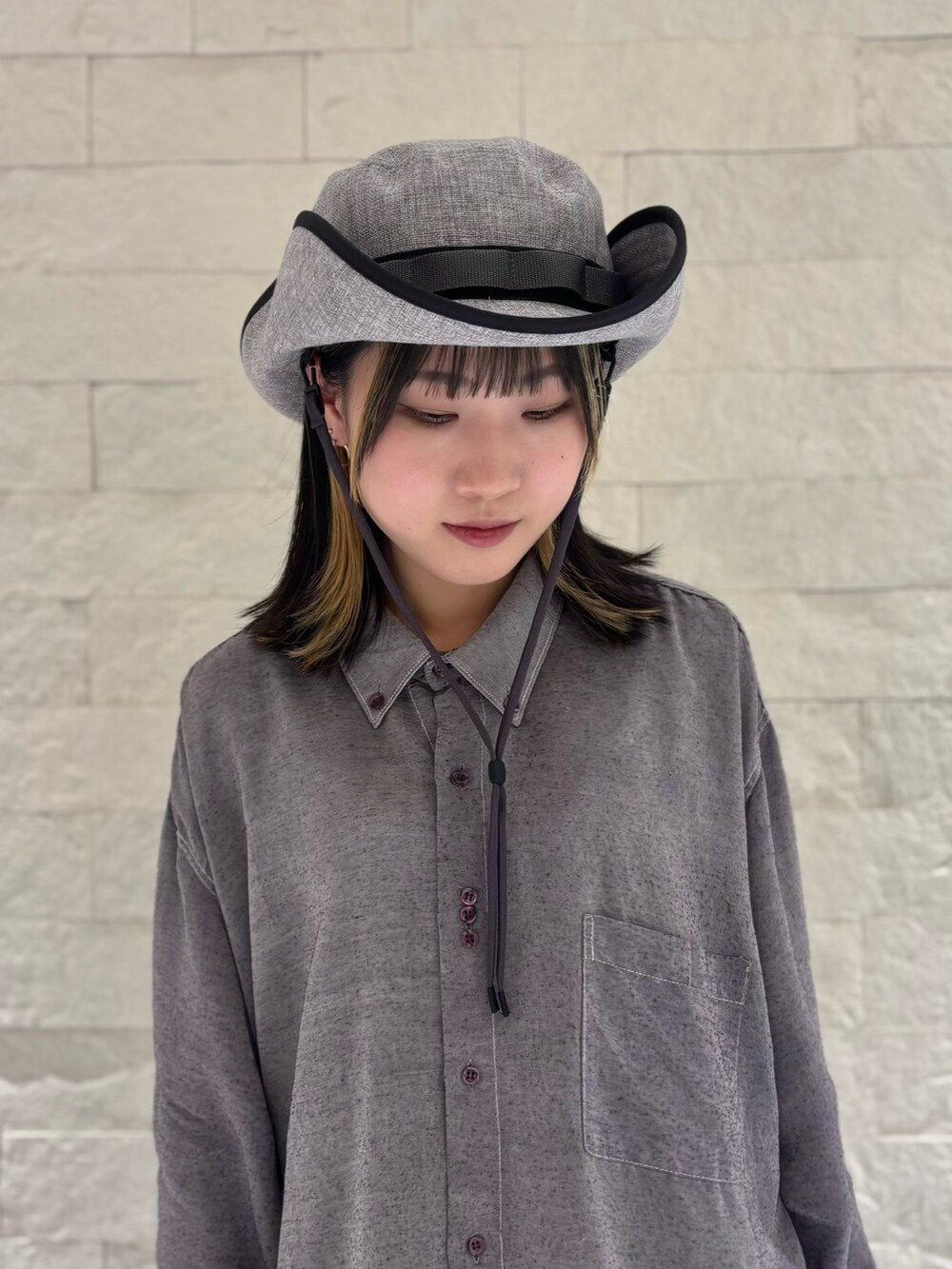 グレー系のシャツ/ブラウス、シルバー系のワンピース/ドレス、ブラック系のデニムパンツを着用したレディースの春コーディネートの4枚目の写真