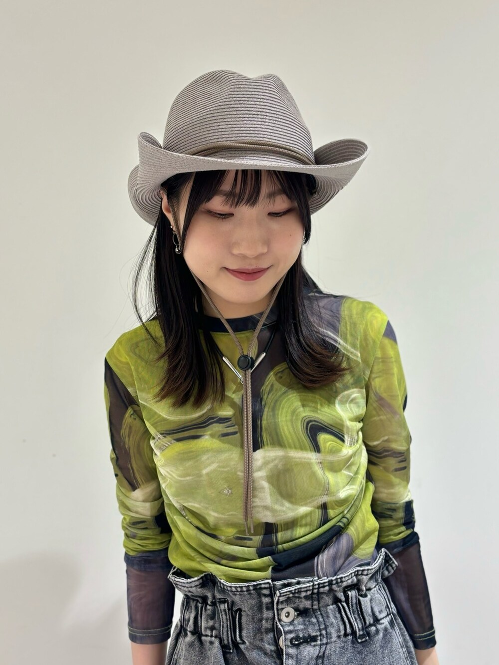 ブラック系のデニムパンツ、ブラック系のシューズ、グレー系のハットを着用したレディースの夏コーディネートの2枚目の写真