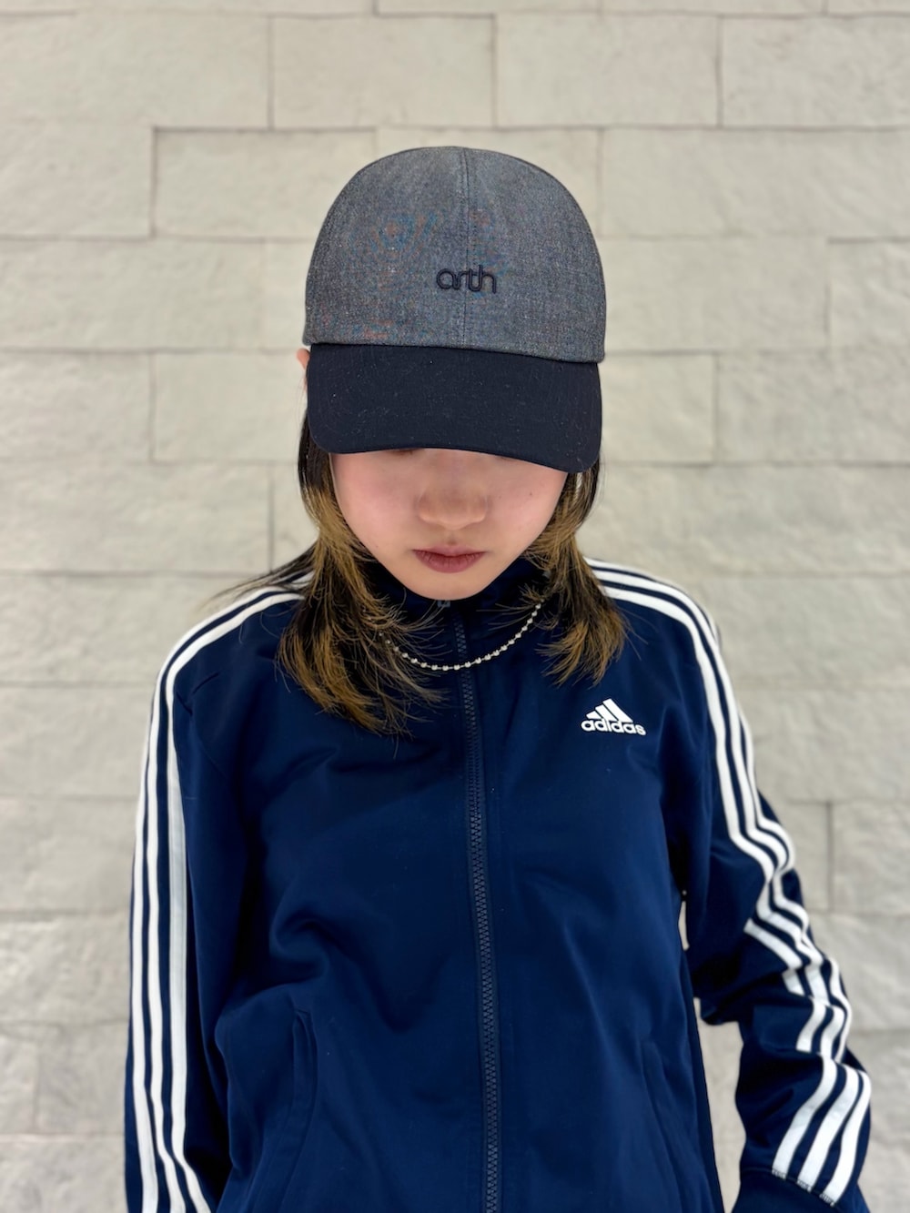 ブルー系のジャージ、グレー系のスカート、ブラック系のスニーカーを着用したレディースの春コーディネートの3枚目の写真