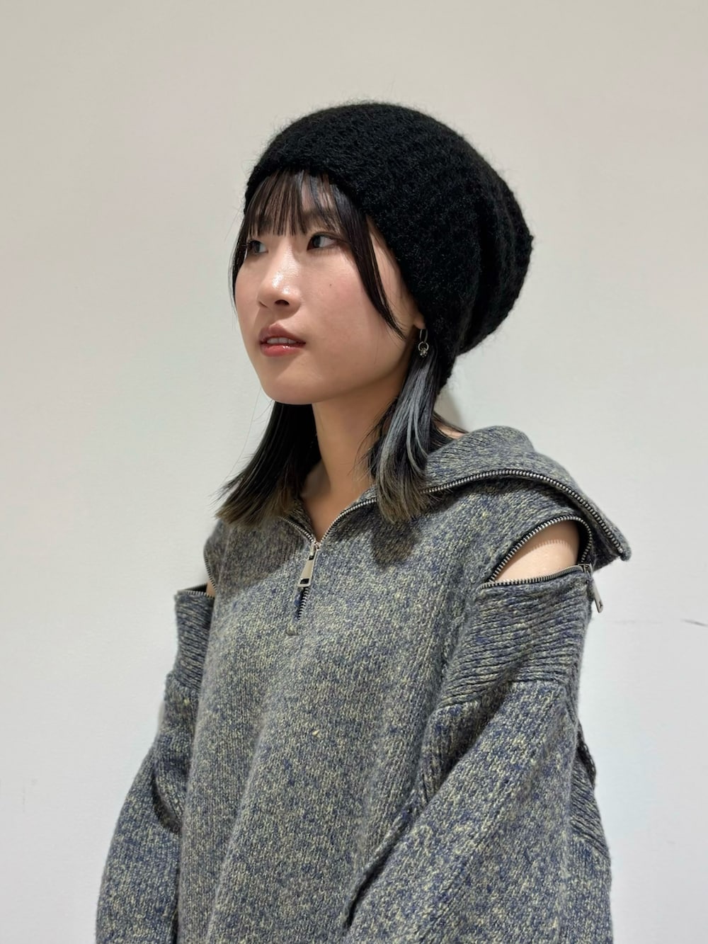 ブラック系のデニムパンツ、ブラック系のローファー、ブルー系のニット/セーターを着用したレディースの秋コーディネートの2枚目の写真