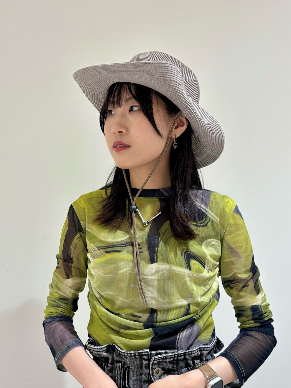 ブラック系のデニムパンツ、ブラック系のシューズ、グレー系のハットを着用したレディースの夏コーディネートの3枚目の写真