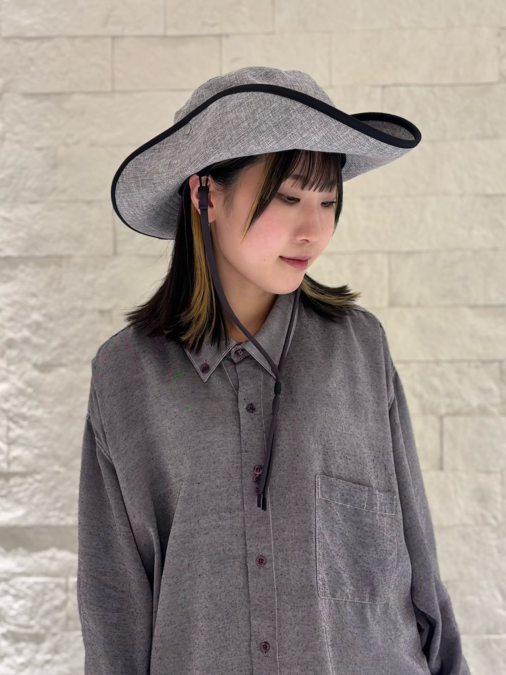 グレー系のシャツ/ブラウス、シルバー系のワンピース/ドレス、ブラック系のデニムパンツを着用したレディースの春コーディネートの2枚目の写真