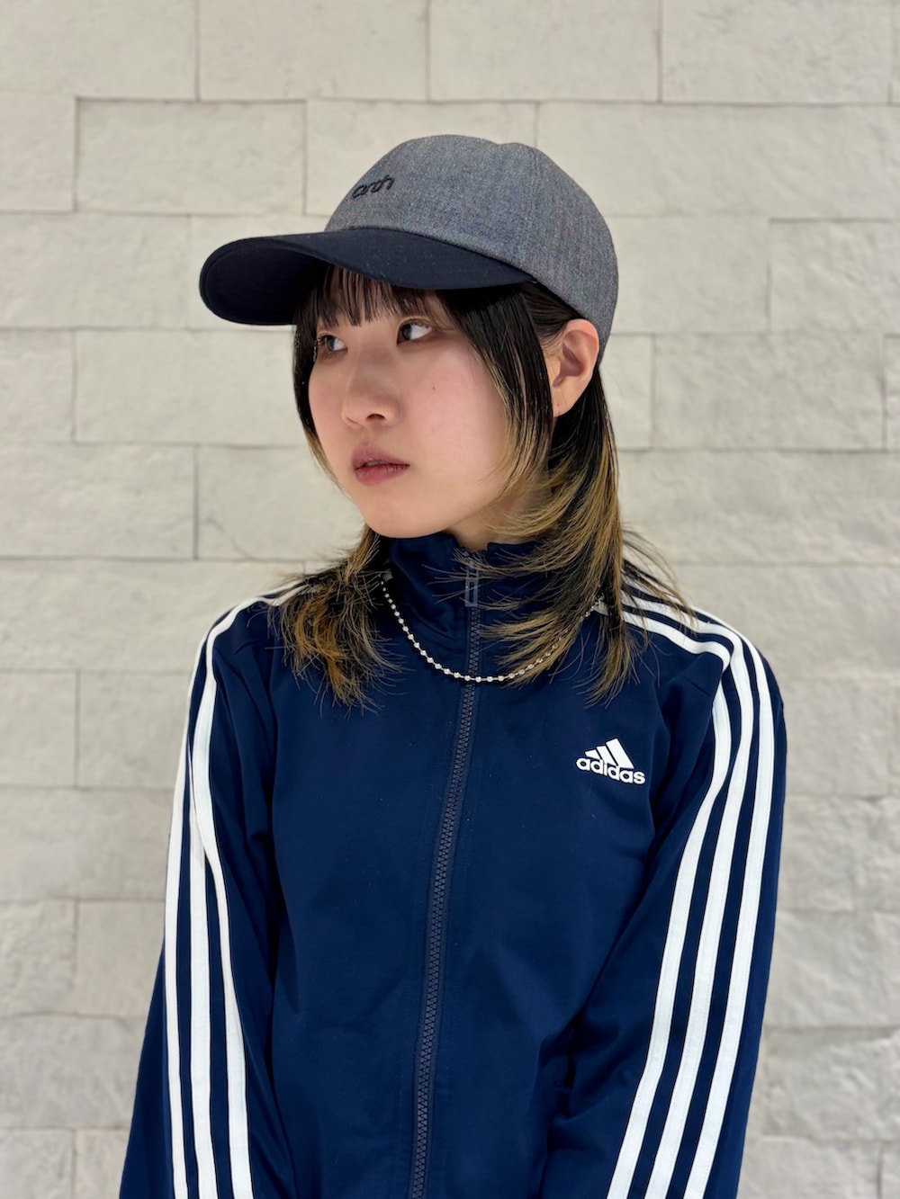 ブルー系のジャージ、グレー系のスカート、ブラック系のスニーカーを着用したレディースの春コーディネートの2枚目の写真