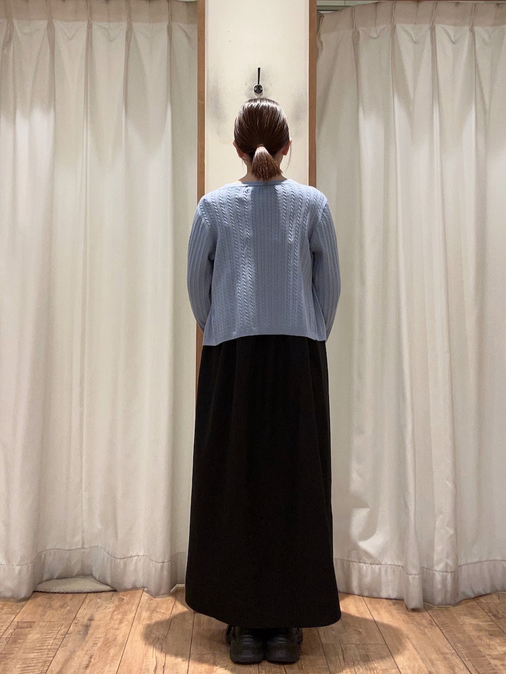 ブラック系のワンピース、ブルー系のカーディガン/ボレロ、ホワイト系のTシャツ/カットソーを着用したレディースの冬コーディネートの2枚目の写真