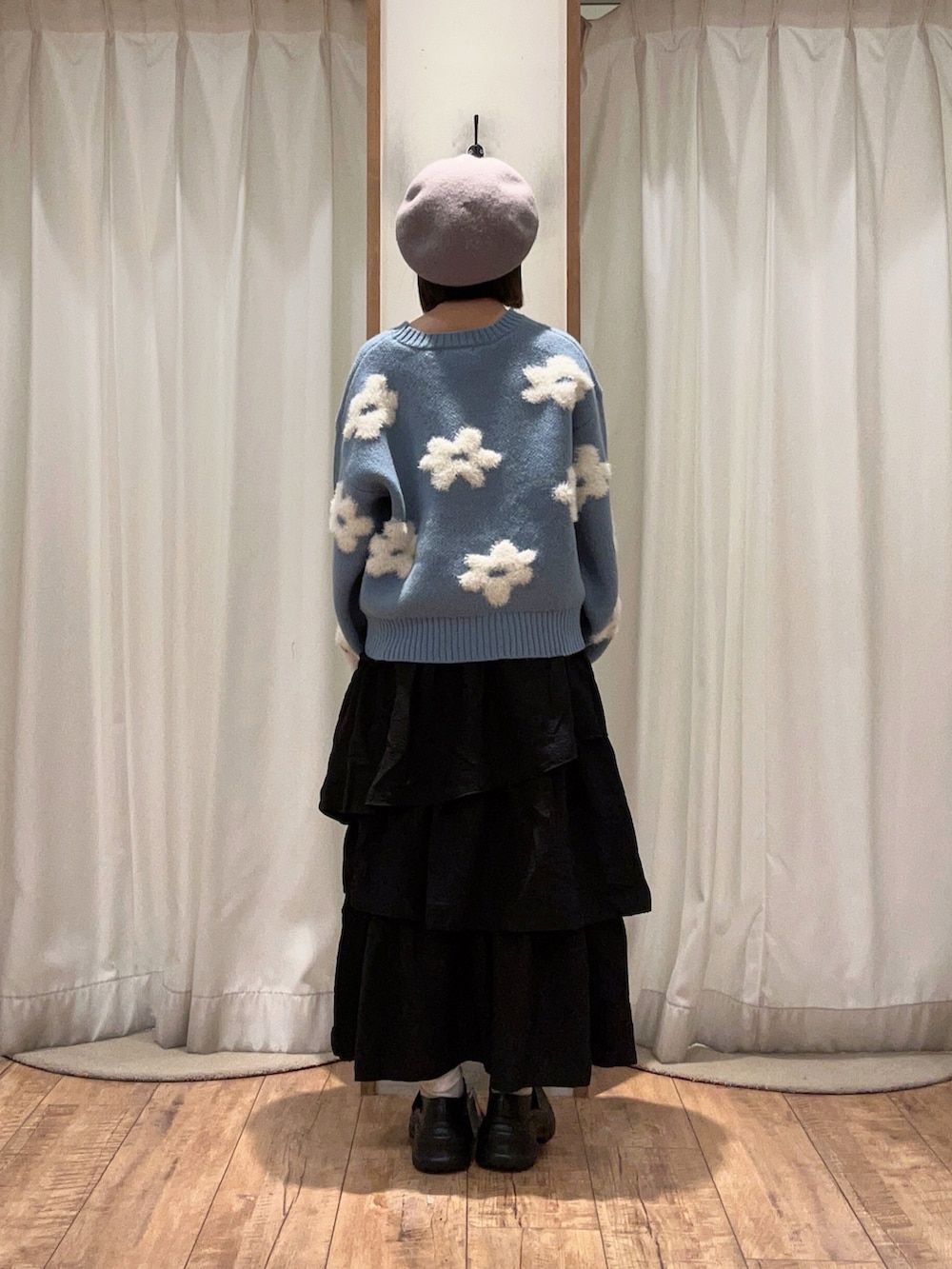 ブラック系のスカート、ブラック系のスニーカー、ブルー系のニット/セーターを着用したレディースの秋コーディネートの3枚目の写真