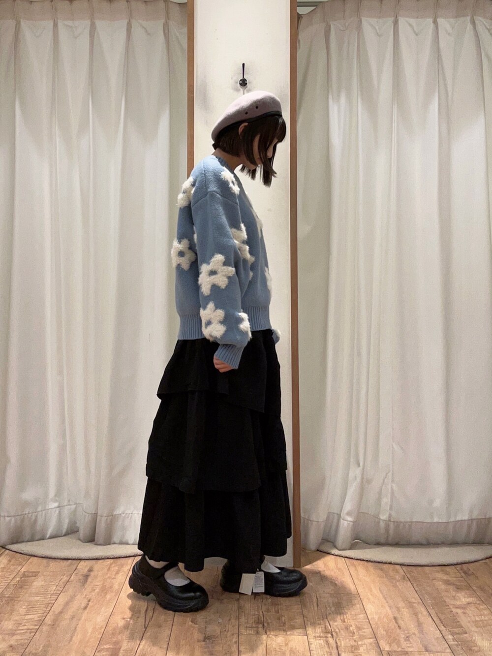 ブラック系のスカート、ブラック系のスニーカー、ブルー系のニット/セーターを着用したレディースの秋コーディネートの2枚目の写真