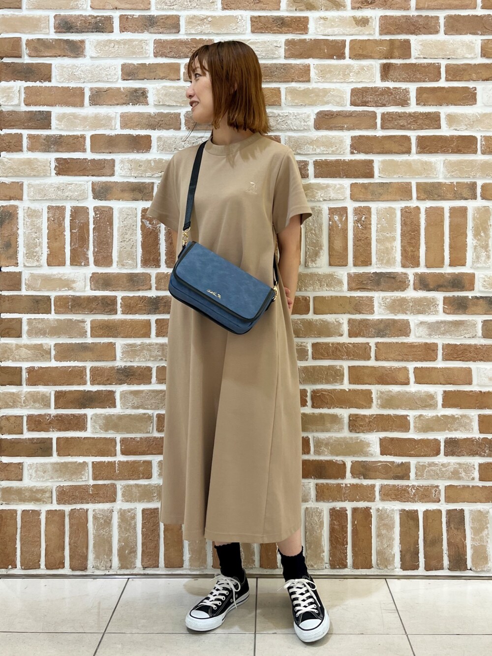 ブラック系のカーディガン/ボレロ、ブルー系のショルダーバッグ、ベージュ系のワンピースを着用したレディースの秋コーディネートの3枚目の写真