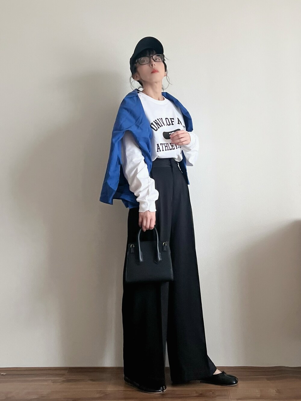 ホワイト系のTシャツ/カットソー、ブルー系のシャツ/ブラウス、ブラック系のパンツを着用したレディースの春コーディネートの2枚目の写真
