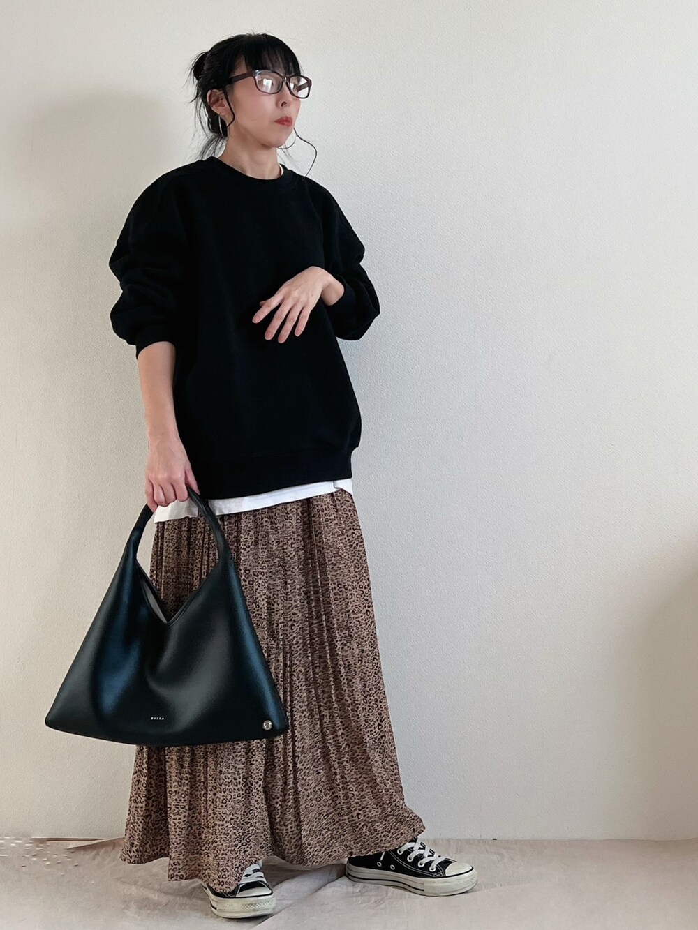 ブラック系のバッグ、ブラウン系のスカート、ブラック系のスニーカーを着用したレディースの冬コーディネートの3枚目の写真