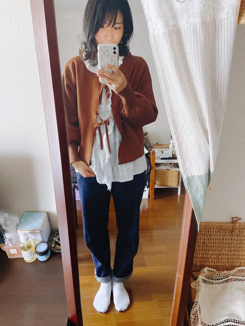 ベージュ系のステンカラーコート、ブラウン系のニット/セーター、ブルー系のシャツ/ブラウスを着用したレディースの冬コーディネートの2枚目の写真