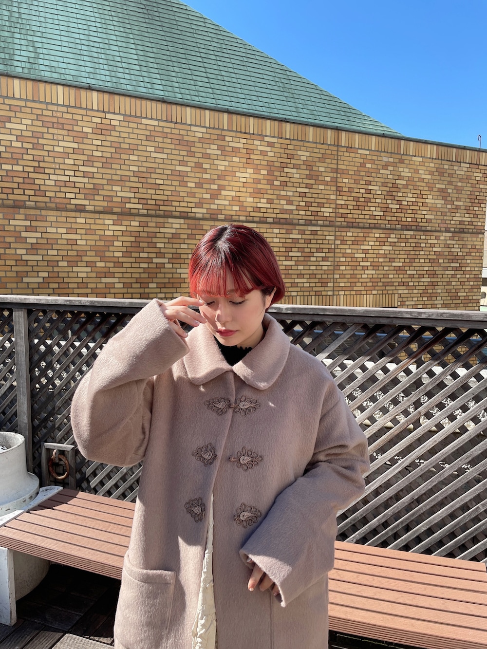 ベージュ系のワンピース、ブラック系のパンプス、ブラック系のニット/セーターを着用したレディースの秋コーディネートの2枚目の写真