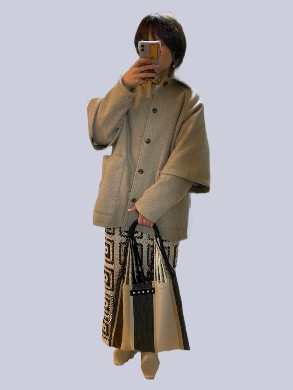ベージュ系のカーディガン/ボレロ、ベージュ系のバッグ、ブラウン系のスカートを着用したレディースの春コーディネートの2枚目の写真