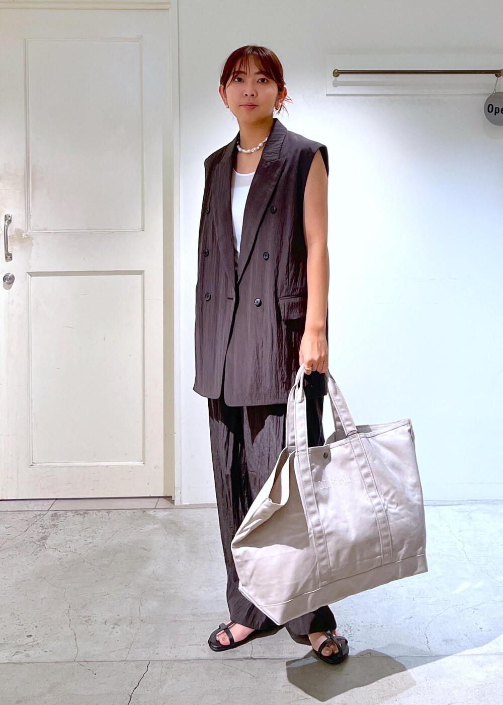 ブラック系のサンダル、ブラウン系のその他パンツ、ブラウン系のベストを着用したレディースの夏コーディネートの2枚目の写真