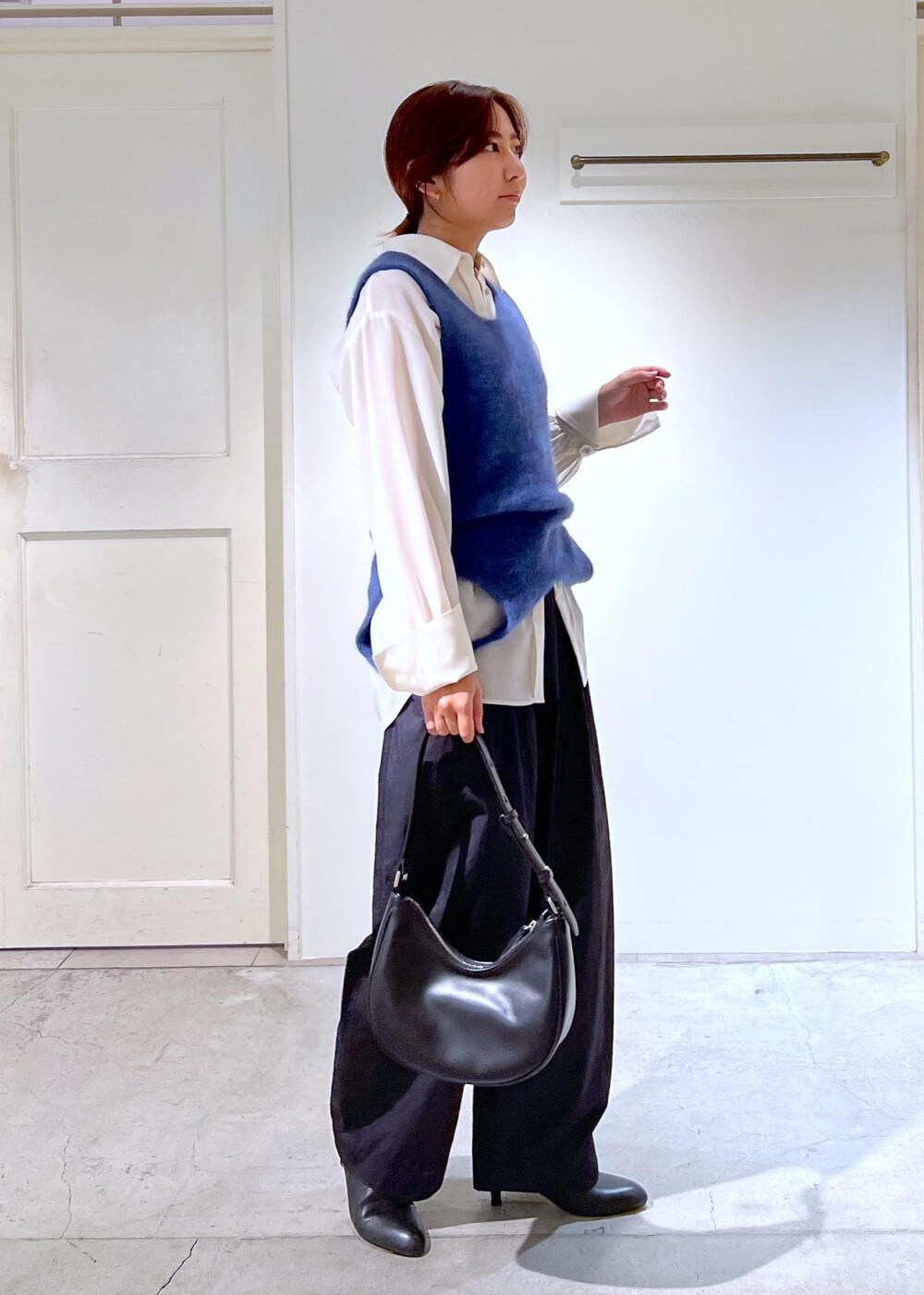 ブルー系のタンクトップ、ホワイト系のシャツ/ブラウス、ブラック系のブーツを着用したレディースの秋コーディネートの4枚目の写真