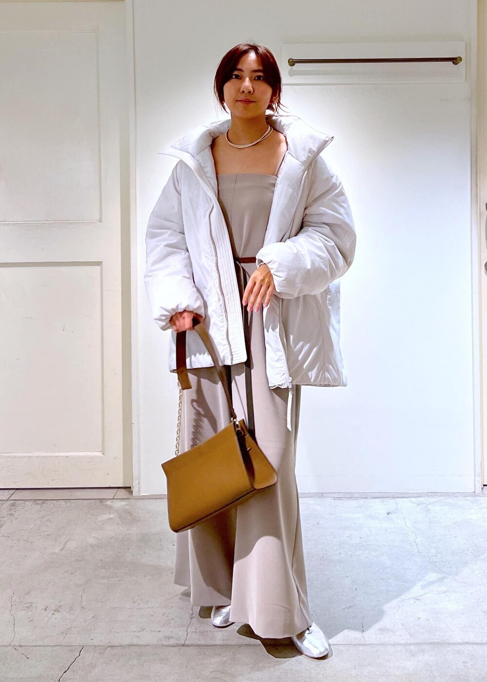 シルバー系のその他シューズ、ホワイト系のダウンジャケット/コート、ブラウン系のショルダーバッグを着用したレディースの秋コーディネートの5枚目の写真