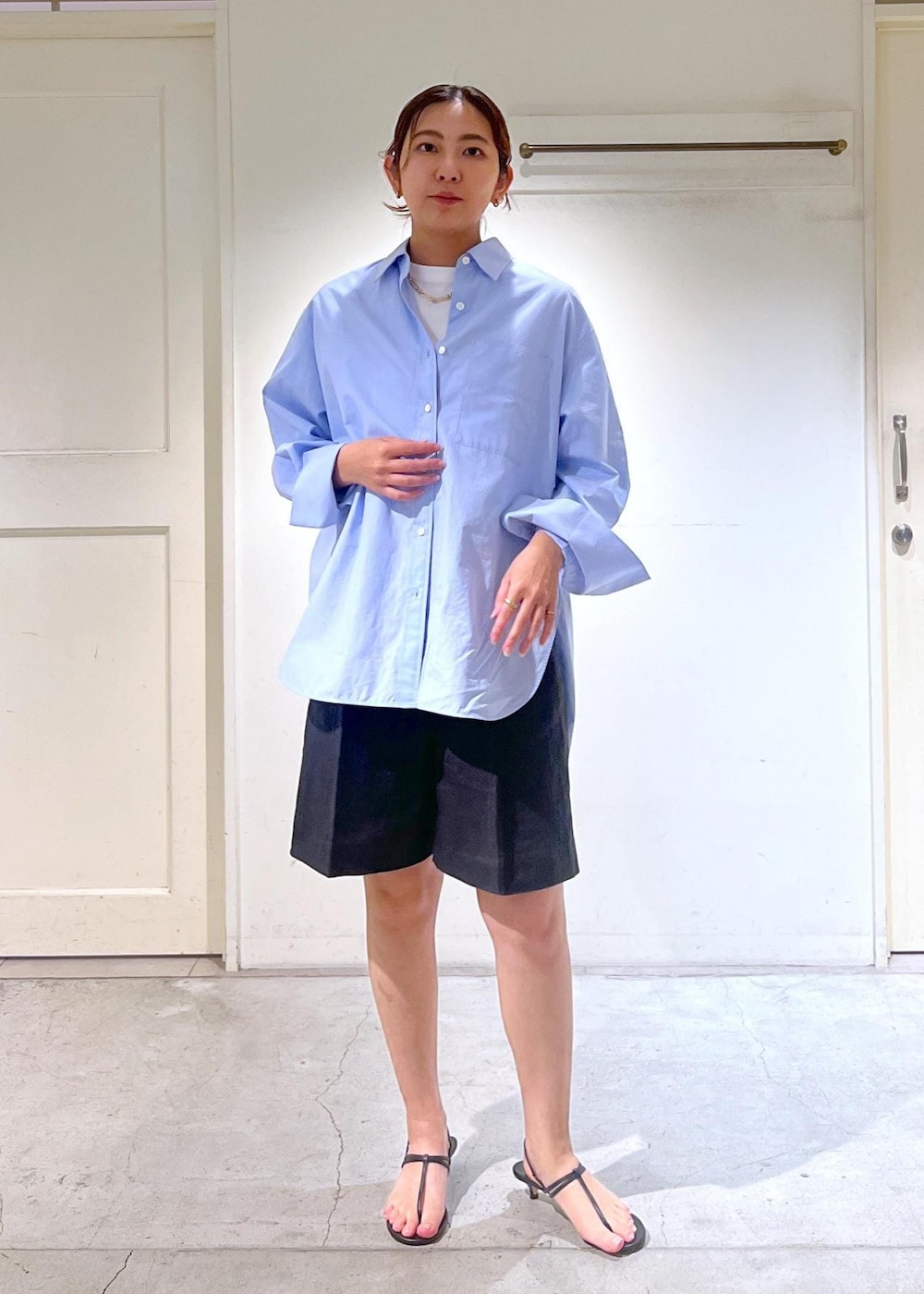 ブラック系のサンダル、ホワイト系のTシャツ/カットソー、ベージュ系のかごバッグを着用したレディースの春コーディネートの2枚目の写真