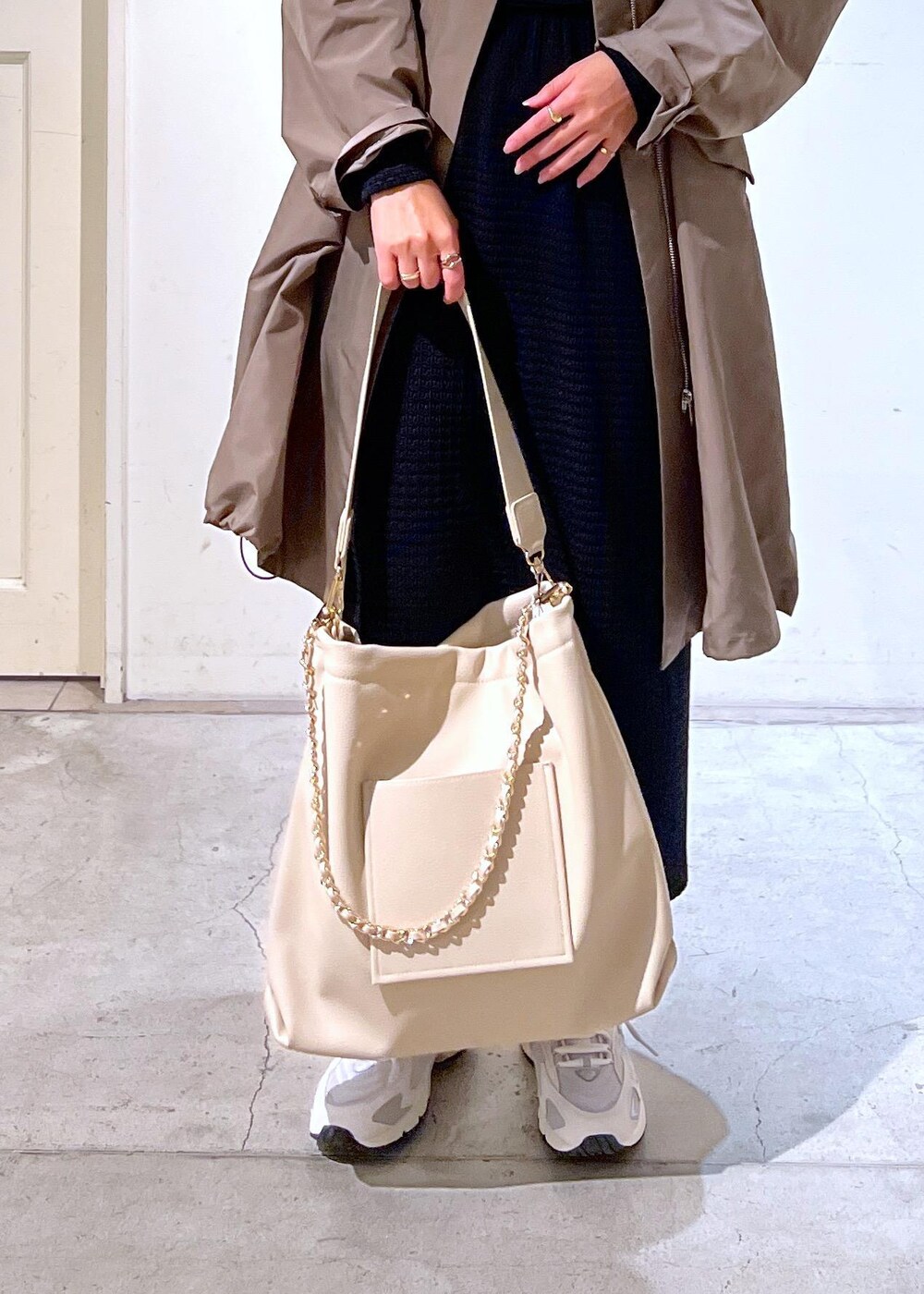 ホワイト系のスニーカー、ブラック系のスカート、ブラウン系のミリタリージャケットを着用したレディースの春コーディネートの6枚目の写真