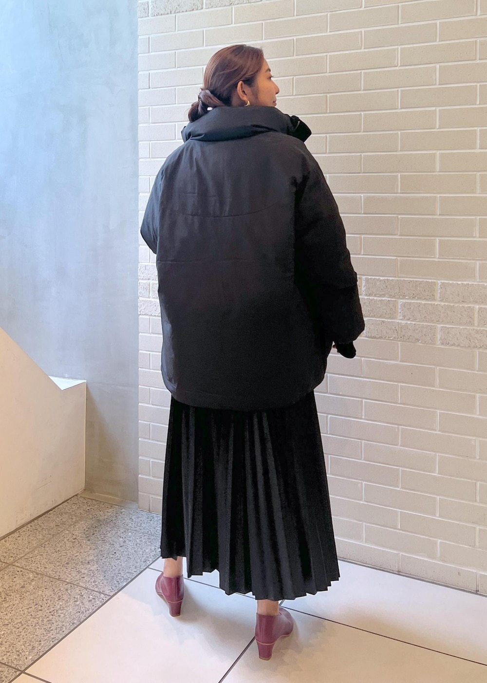 ブラック系のシャツ/ブラウス、ブラック系のダウンジャケット/コート、ホワイト系のTシャツ/カットソーを着用したレディースの秋コーディネートの4枚目の写真