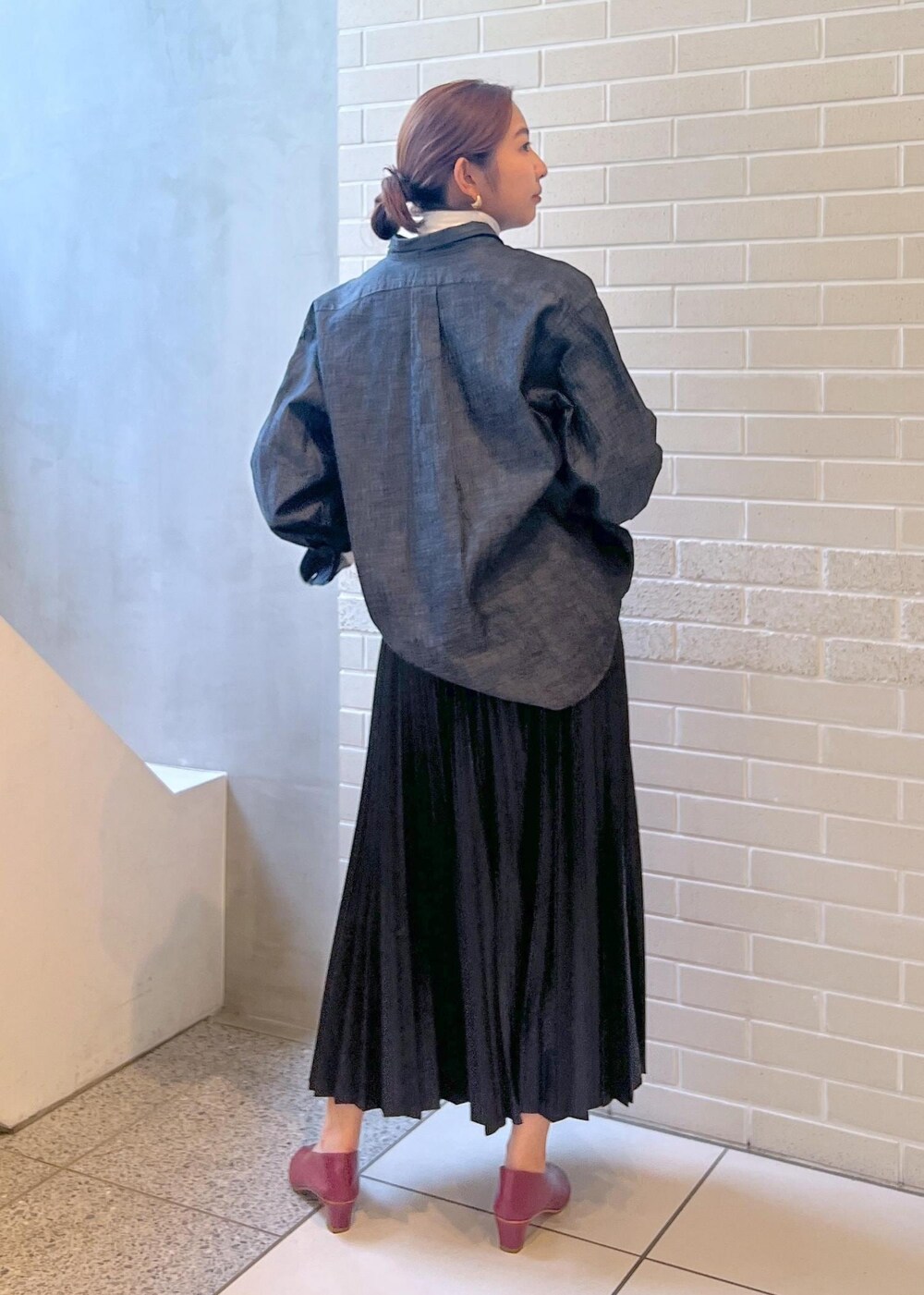 ブラック系のシャツ/ブラウス、ブラック系のダウンジャケット/コート、ホワイト系のTシャツ/カットソーを着用したレディースの秋コーディネートの6枚目の写真