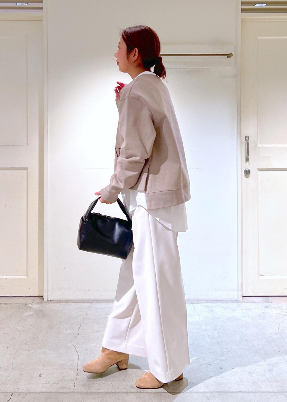 ホワイト系のシャツ/ブラウス、ブラック系のハンドバッグ、ブラウン系のブーツを着用したレディースの冬コーディネートの4枚目の写真