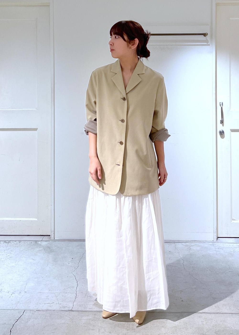 ベージュ系のパンプス、ベージュ系のテーラードジャケット、ホワイト系のスカートを着用したレディースの春コーディネートの5枚目の写真