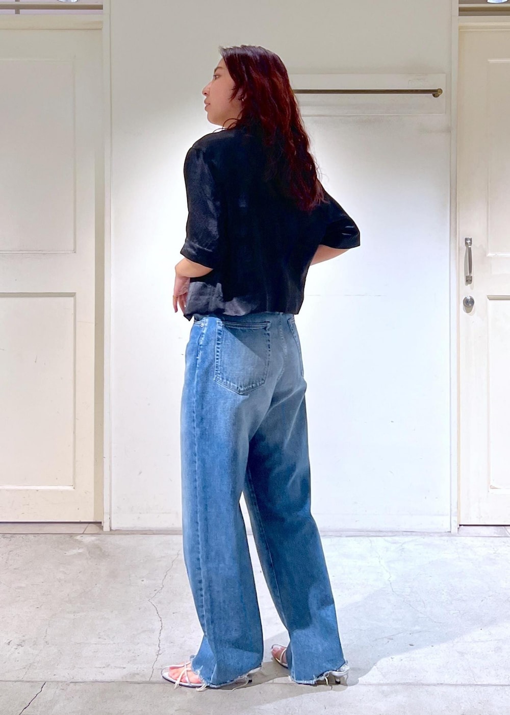 ブルー系のデニムパンツ、シルバー系のサンダル、ホワイト系のかごバッグを着用したレディースの夏コーディネートの5枚目の写真