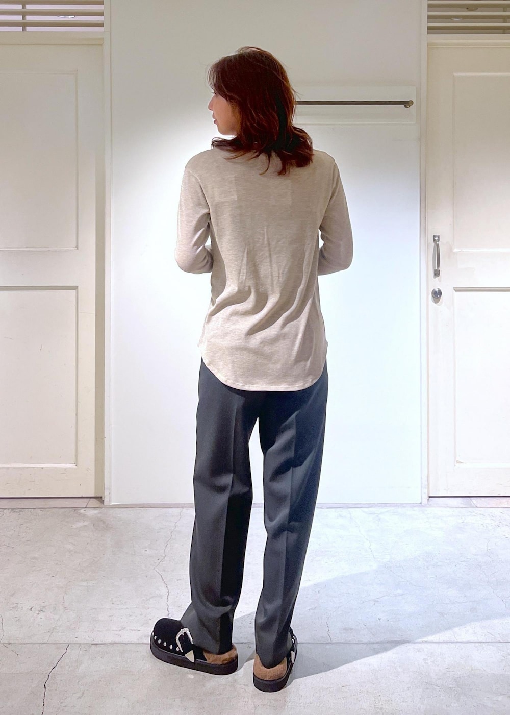 ブラック系のショルダーバッグ、グレー系のスラックス、ゴールド系のTシャツ/カットソーを着用したレディースの秋コーディネートの6枚目の写真